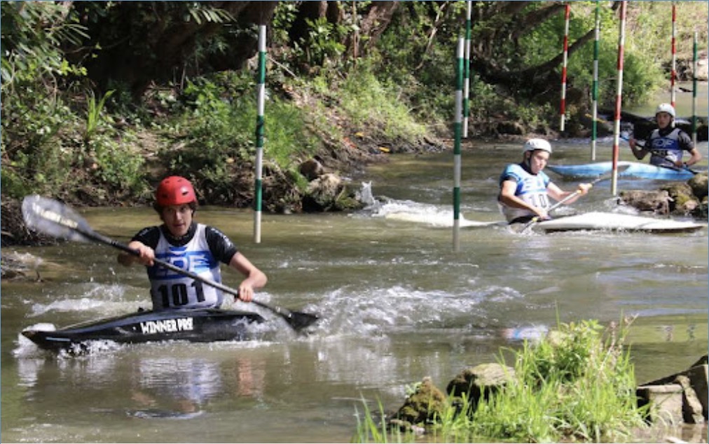 Pagayeur en compétition de slalom sur une rivière, entre les portes